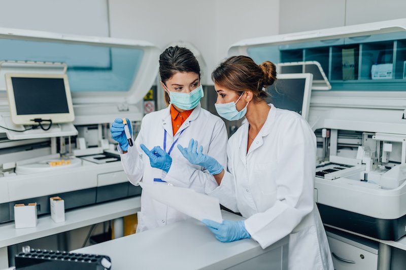 Two,Female,Scientists,Or,Technicians,With,Face,Protective,Masks,Work