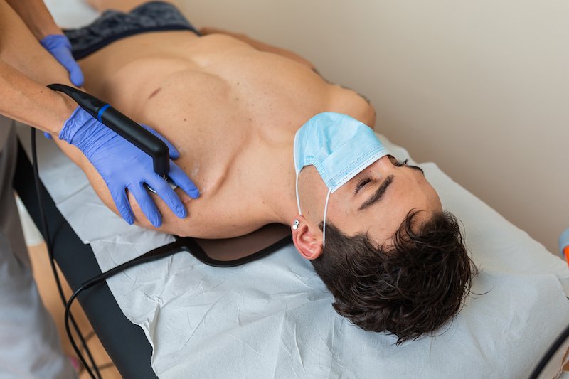 Woman,Physiotherapist,With,Mask,Does,A,Diathermy,To,A,Man